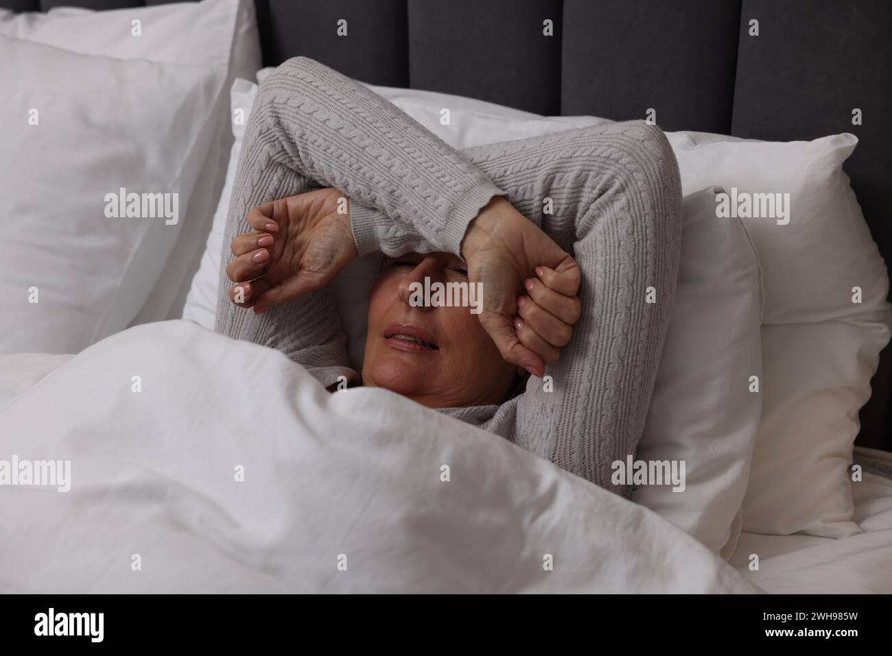 Menopause, sleep problems. Woman suffering from insomnia in bed Stock