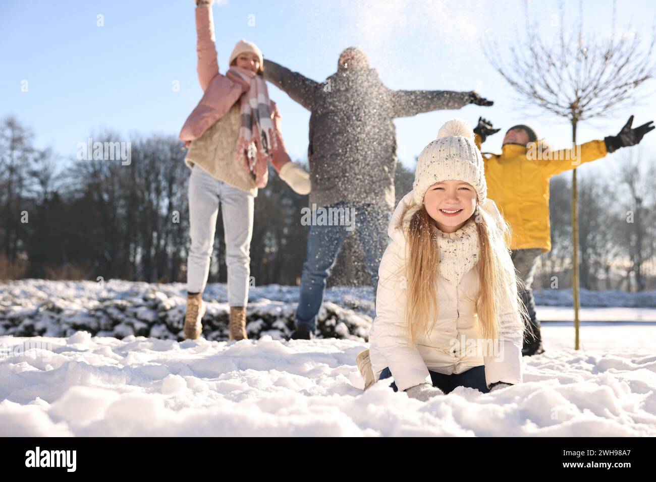 Happy family playing with snow in sunny winter park Stock Photo