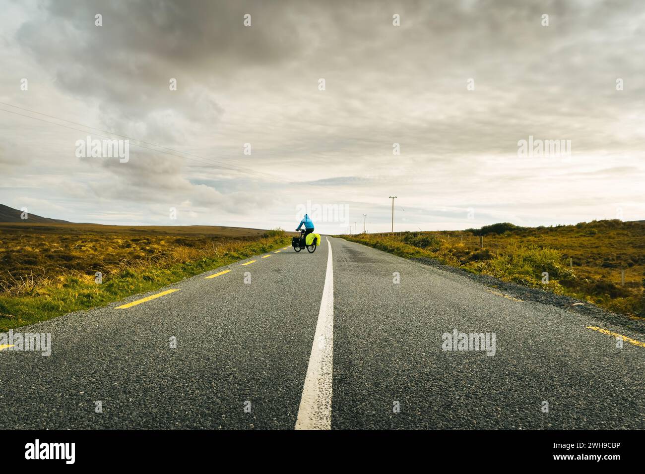 Cyclist bicycle touring drive turn around on wild atlantic way road in Ireland. Travel adventure outdoors Stock Photo