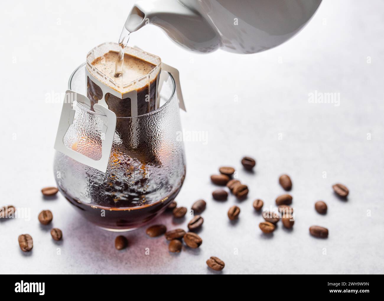 A glass of freshly brewed drip coffee. Pouring water into ground coffee