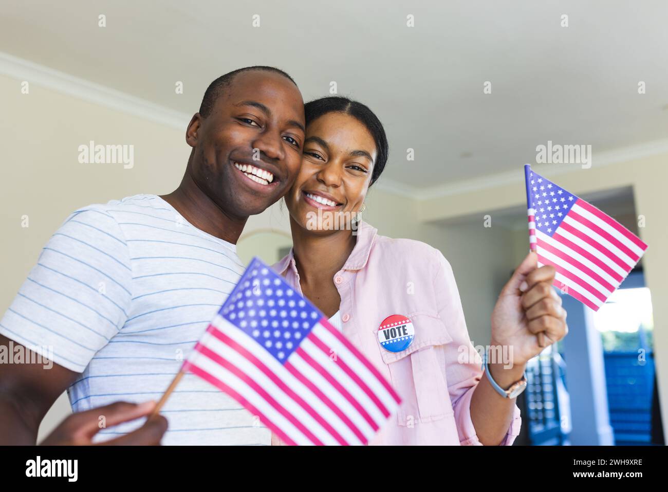 Couple proudly displays voting stickers, celebrating democracy at home. Stock Photo
