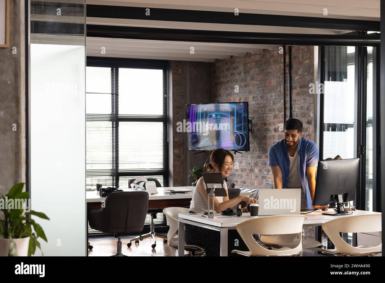 Asian woman and African American man collaborate in a modern casual business office Stock Photo