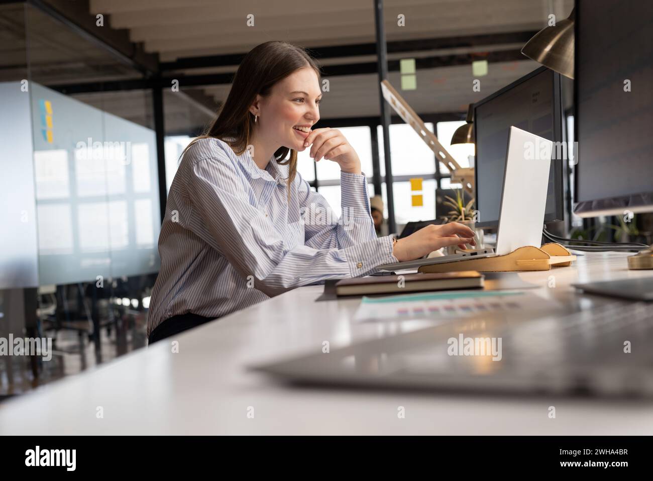 Young Caucasian woman works at her casual business office desk Stock Photo