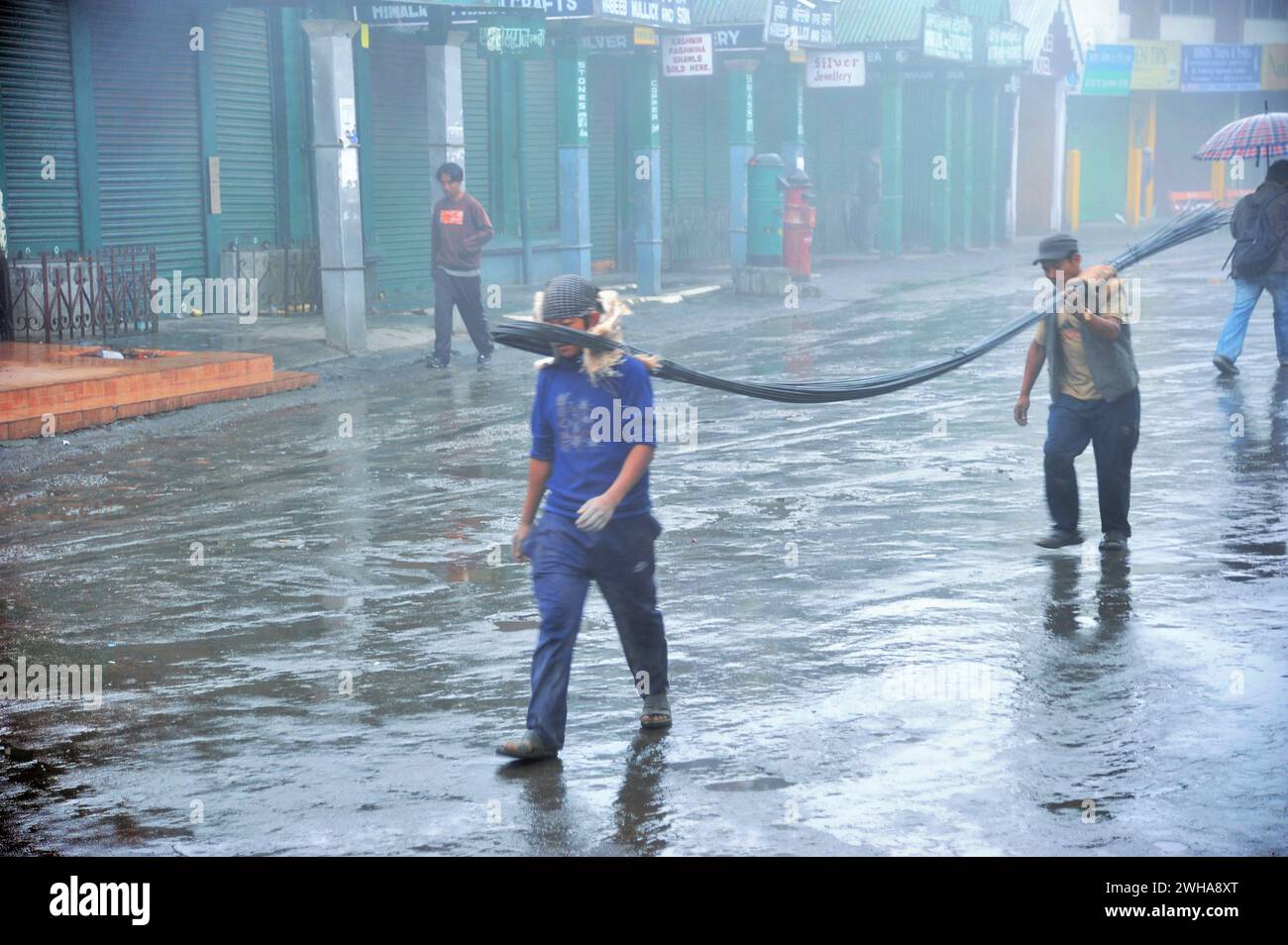 Men carrying iron bars, Mall Road, Chowrasta, Darjeeling, West Bengal, India, Asia Stock Photo