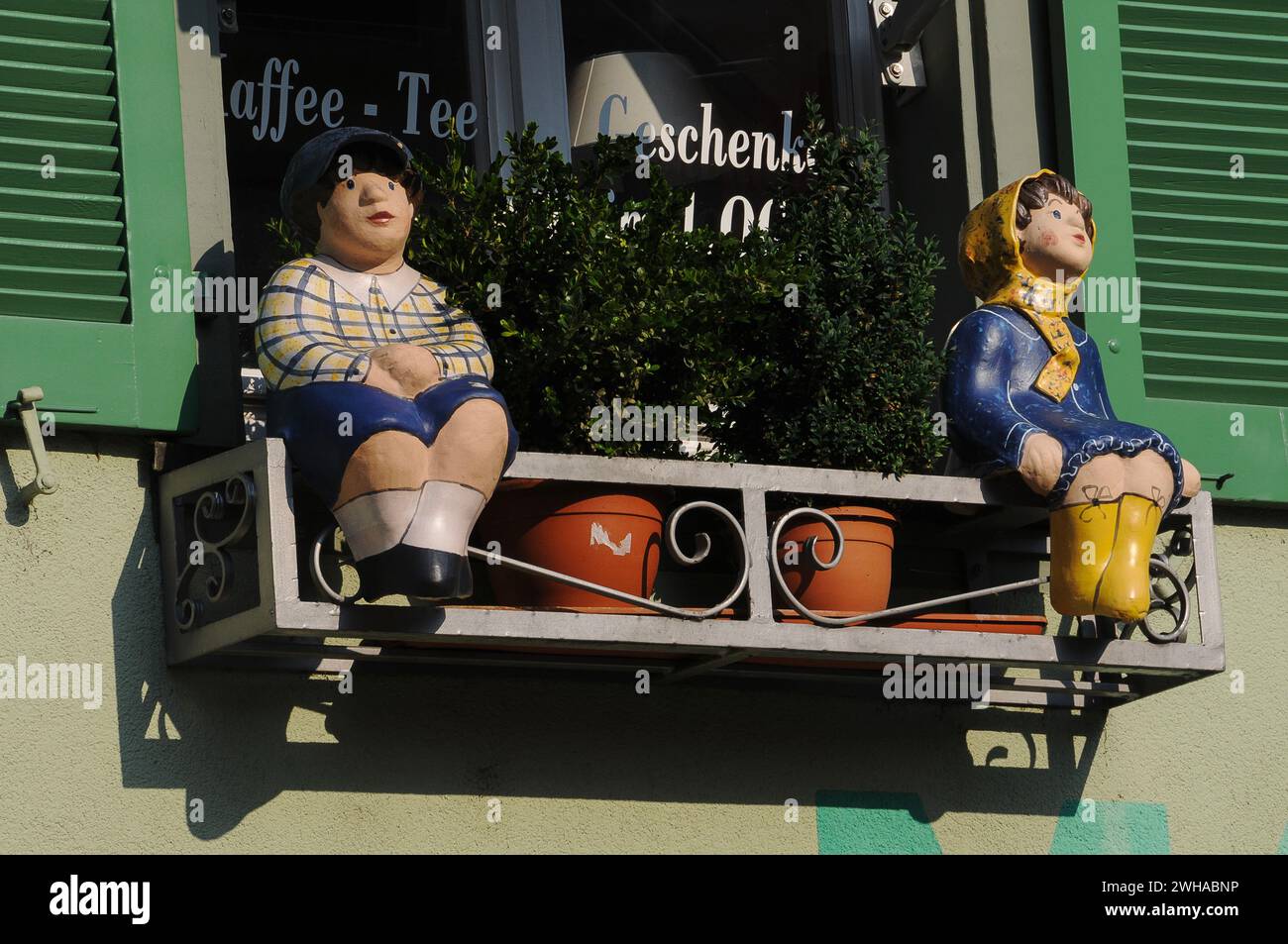 Models of children sit on a window box outside a cafe and gift shop in the tourist destination town of Staufen im Breisgau, in the Breisgau-Hochschwarzwald district of Baden-Württemberg in Germany. Stock Photo