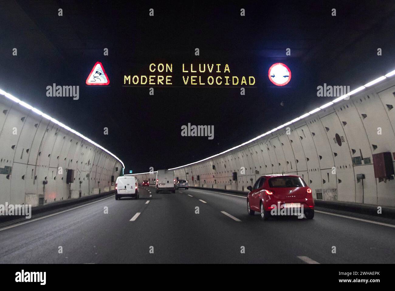 A lighted road sign warns of rain during squall 'Karlotta' on February