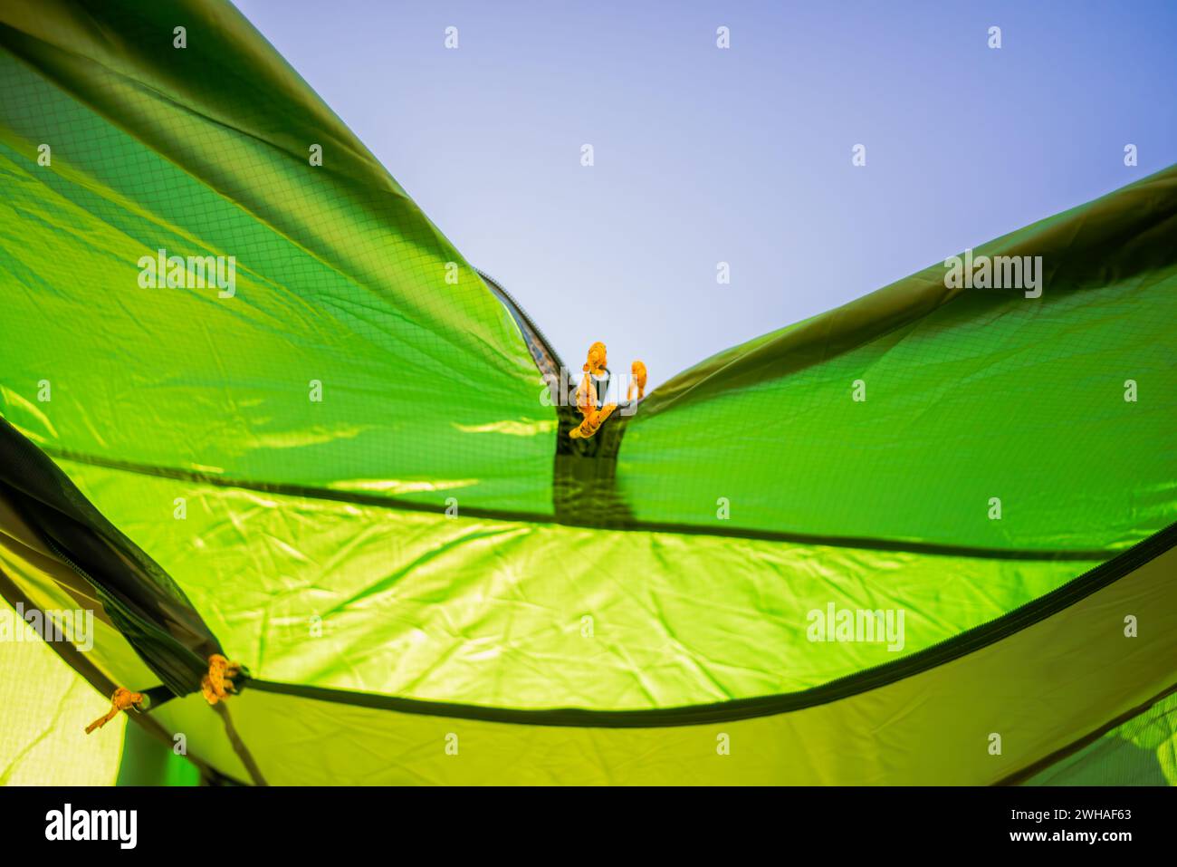 Close-up of a green tent zipper, inviting you to enter the world of outdoor adventure. Unzip and explore the beauty of nature Stock Photo