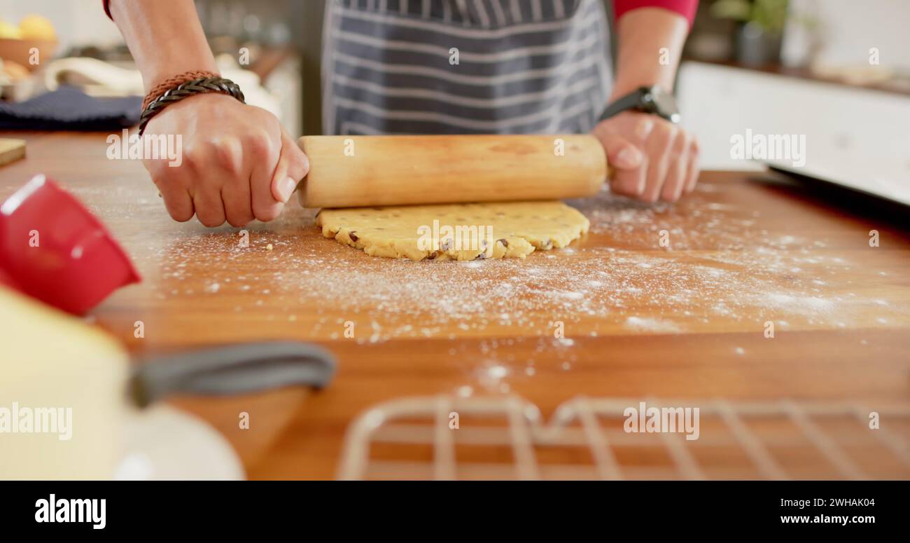 Person rolls out dough on a kitchen counter Stock Photo