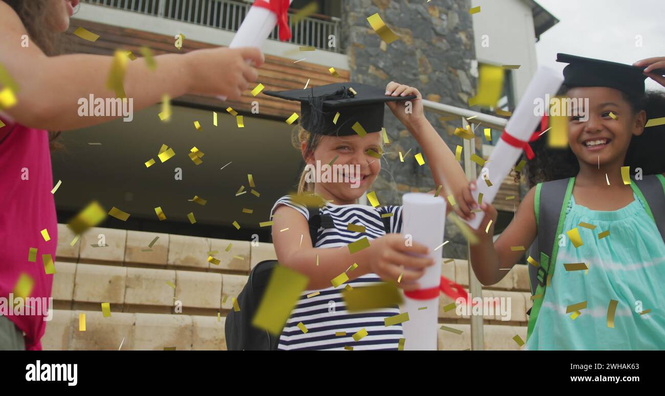 Image of gold confetti over celebrating diverse schoolgirls with mortar boards and diplomas Stock Photo