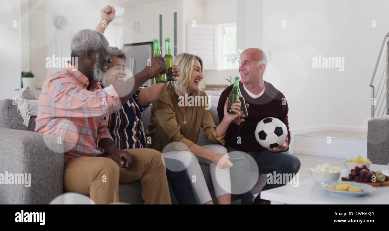 Image of cup icons over diverse group of seniors watching tv Stock Photo