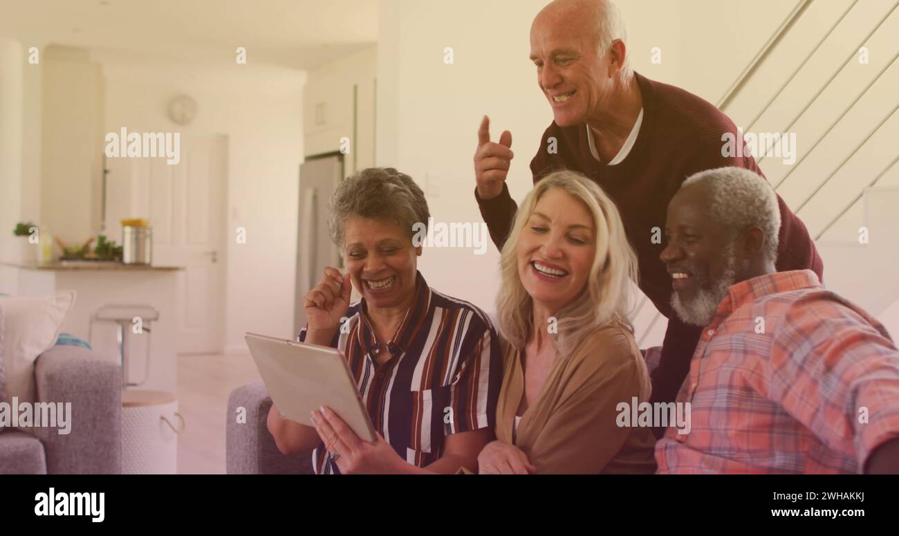 Image of emoji icons over diverse group of seniors with tablet Stock Photo