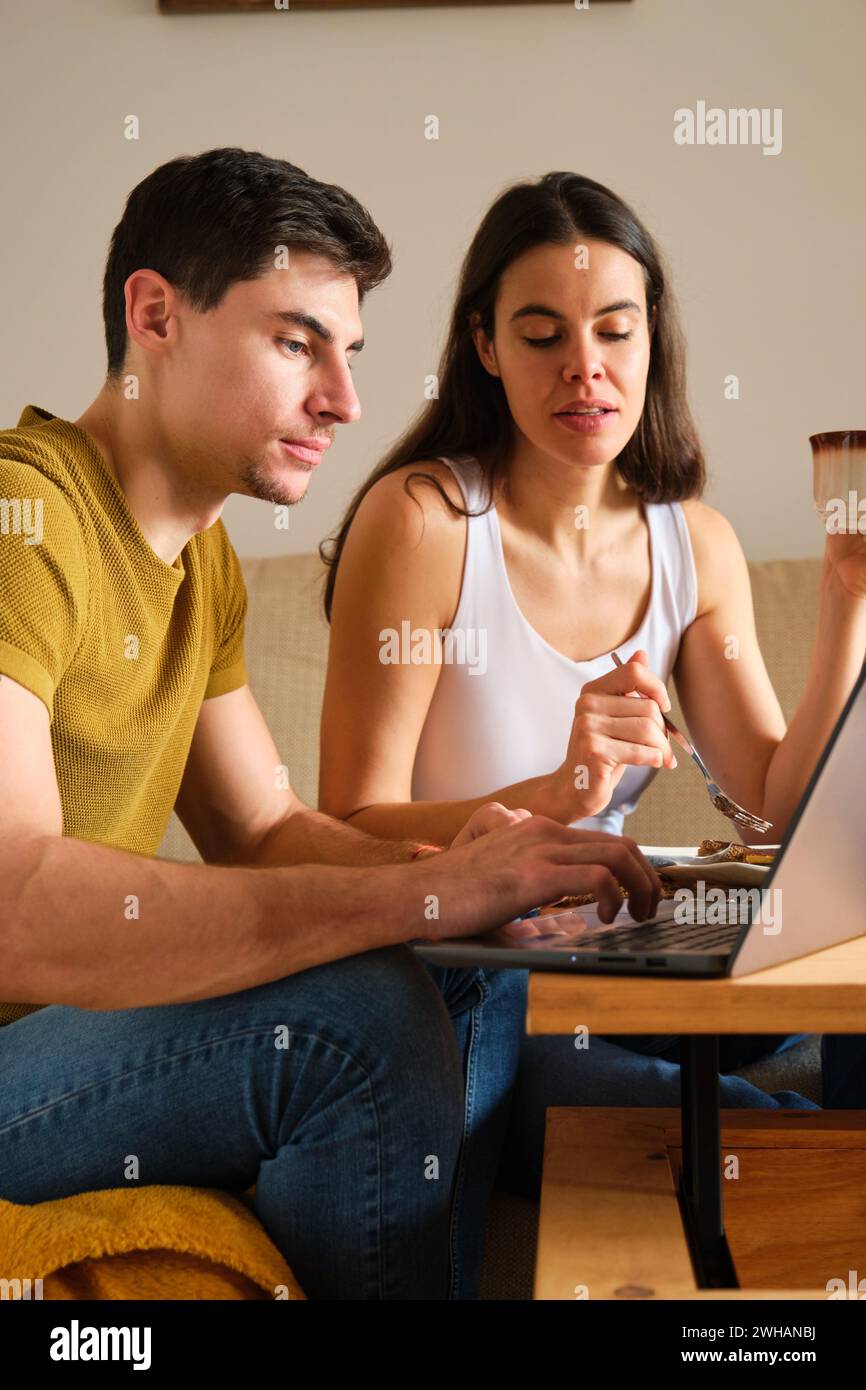 Spanish couple using the laptop while having breakfast. Stock Photo
