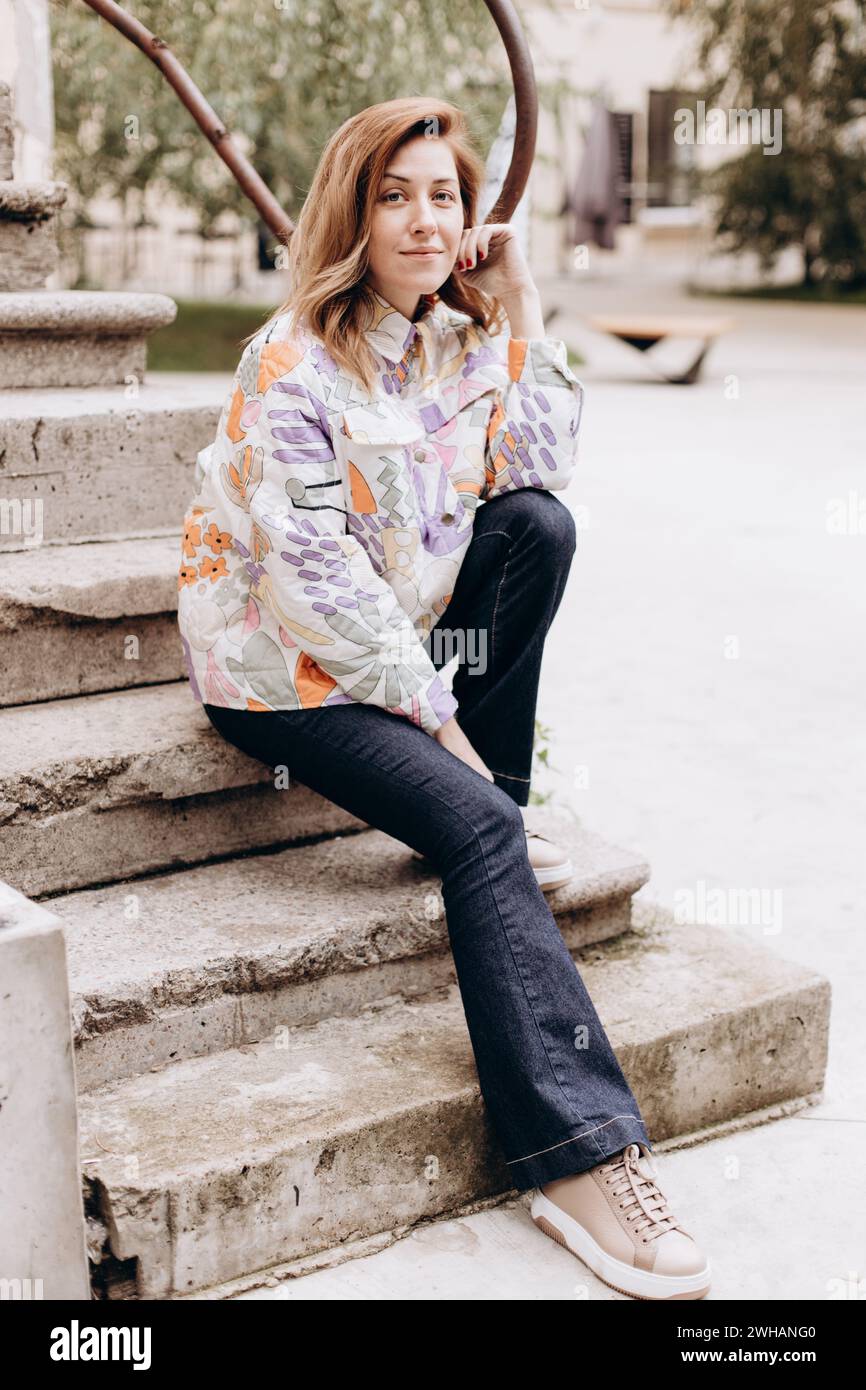 Portrait of woman in casual clothes sitting on the steps Stock Photo