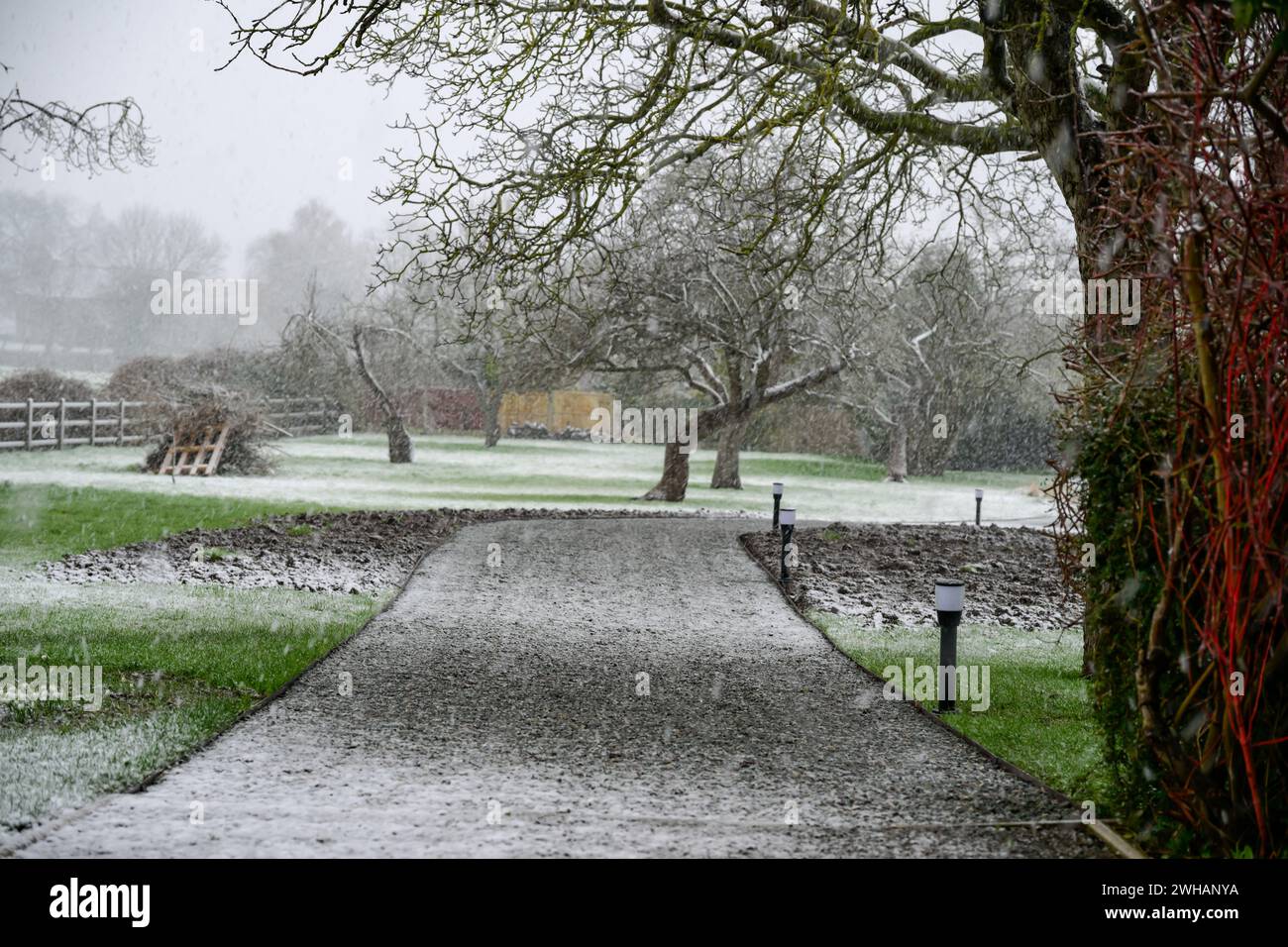 A view down a driveway with a sprinkling of snow Stock Photo