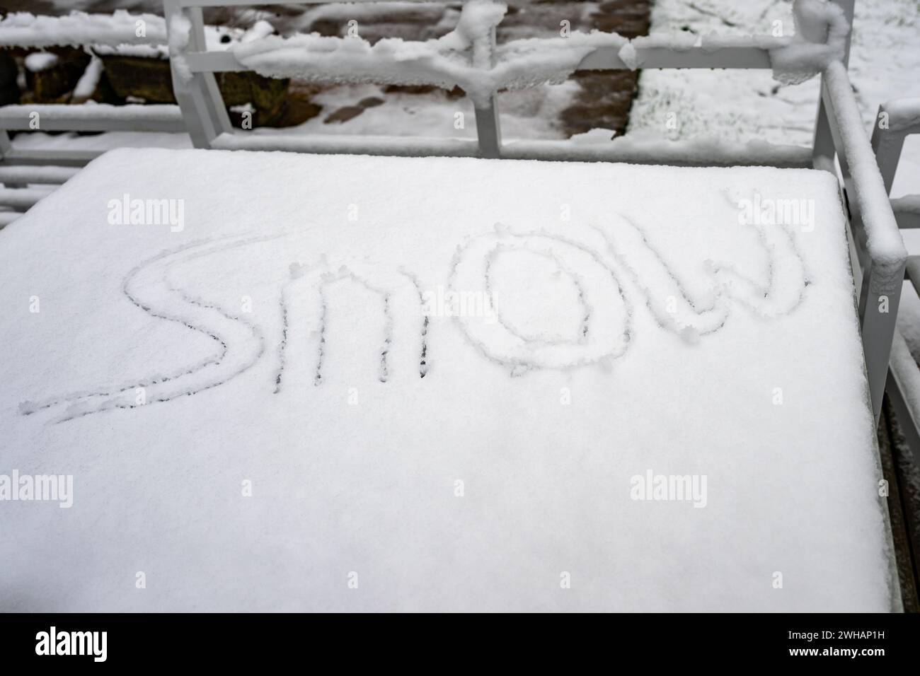 SNOW snow letters on a table top, written in the snow Stock Photo
