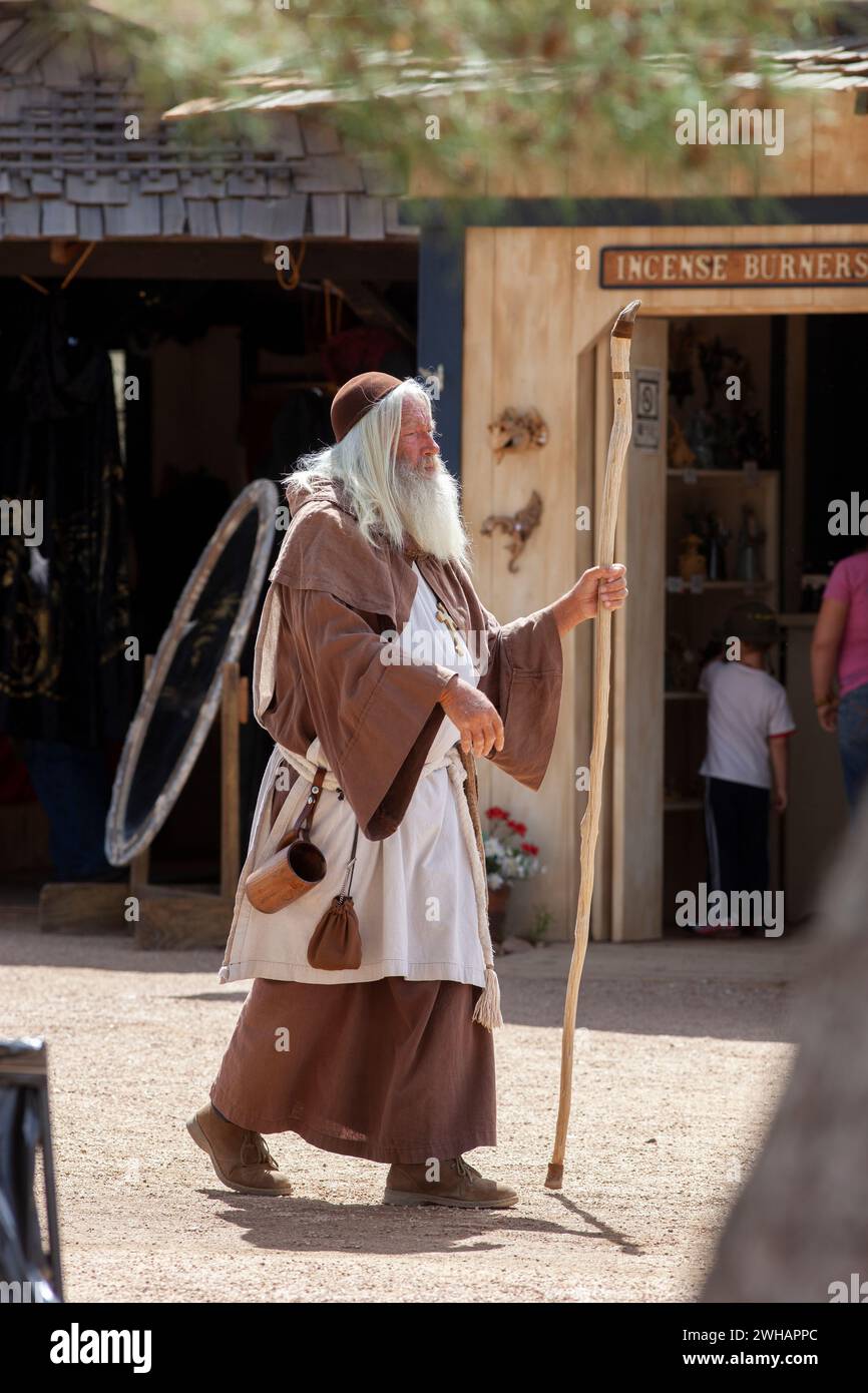 A bearded renaissance man in robes walking with staff vertical Stock ...
