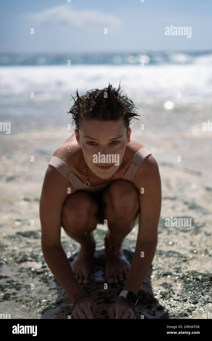 Young woman bathes in the ocean washes face salt water, beach holiday Stock Photo