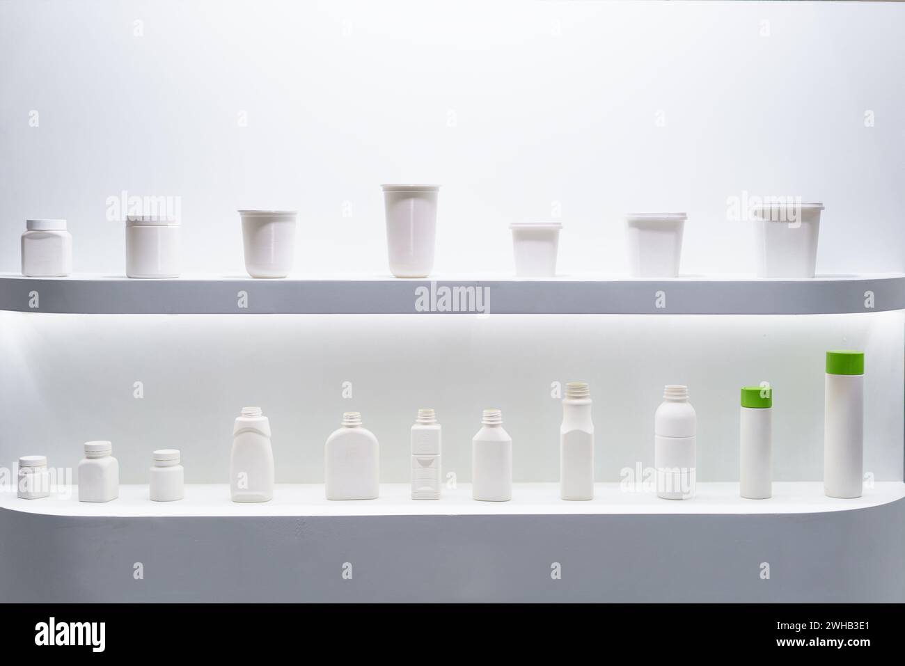 An elegant display of various white packaging containers on shelves, featuring a clean and minimalist design aesthetic suitable for multiple product t Stock Photo