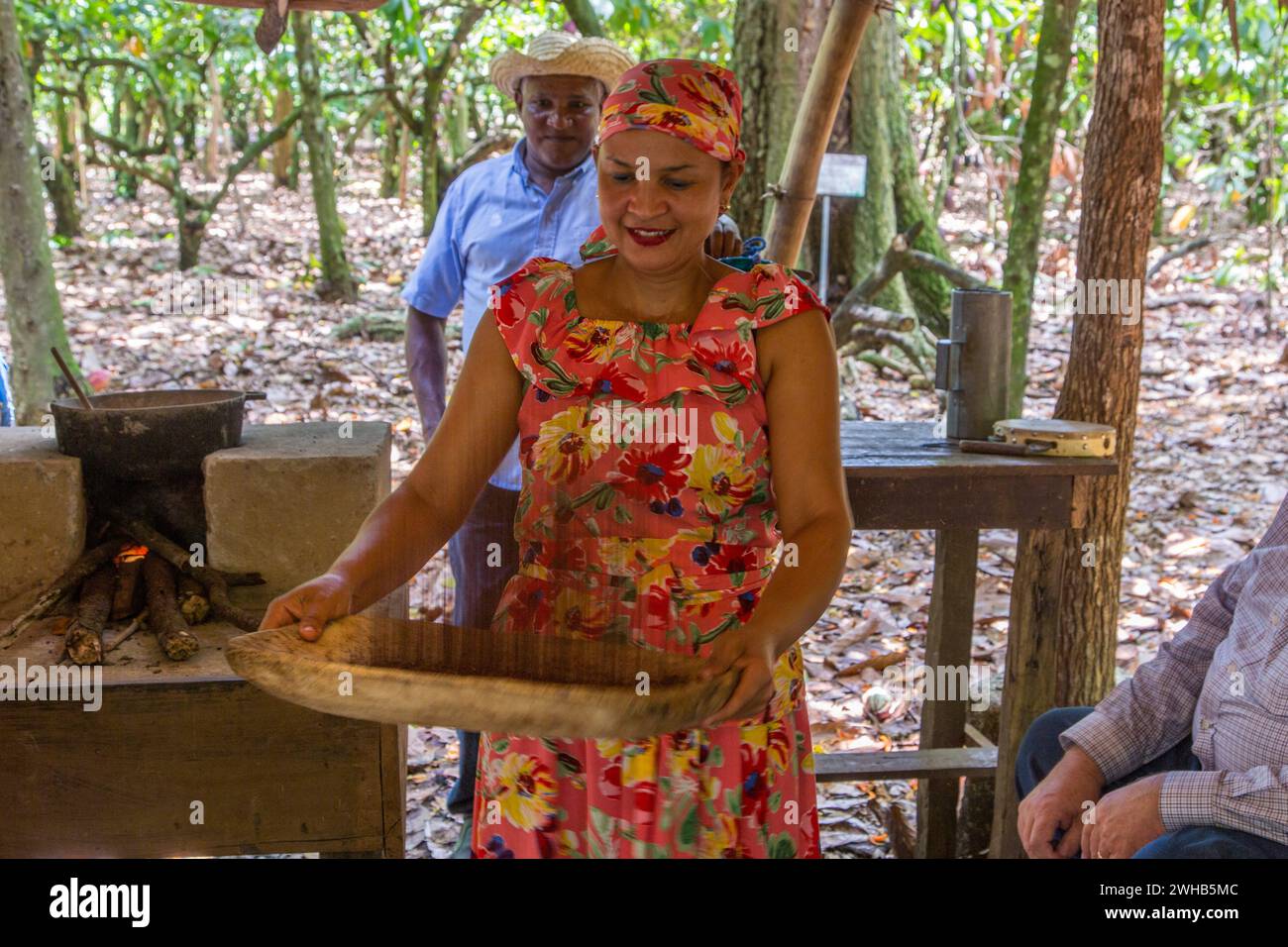 A worker demonstrates the traditional method of winnowing dried cacao