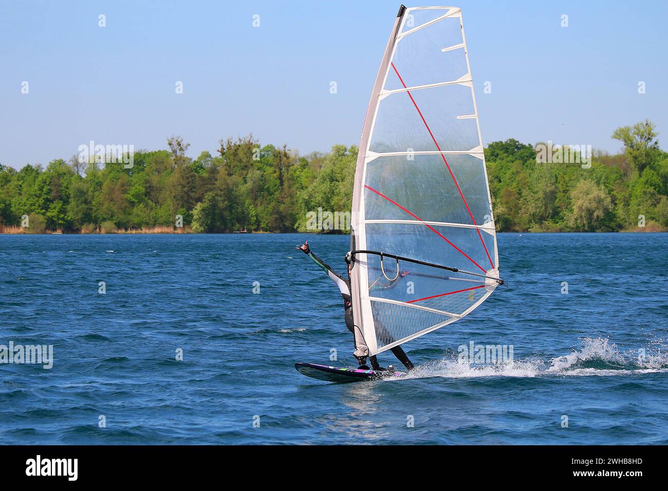 Windsurfing girl showing the surfers greeting sign 'shaka' (Lake in Baden, Germany) Stock Photo