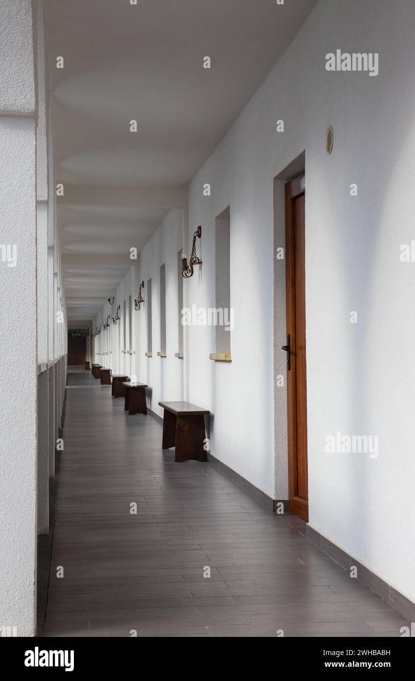 Rows of wooden benches line the hallway Stock Photo