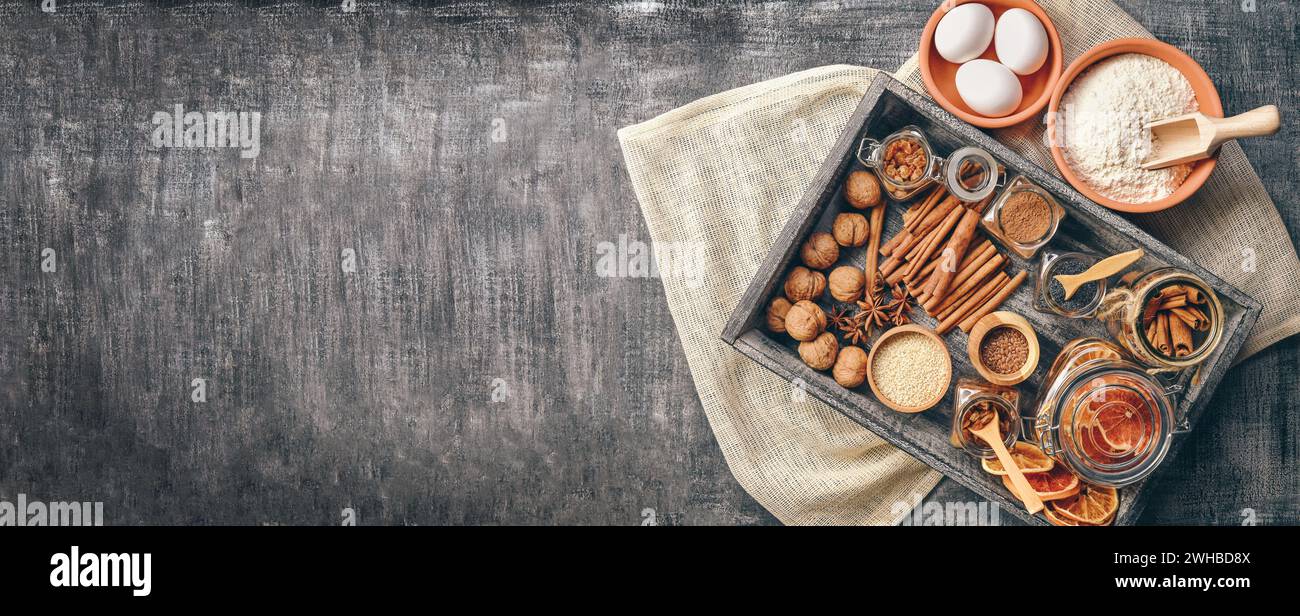 Baking love. Bakery background. Baking ingredients and kitchen utensils on the black background. Flour, almond nuts, eggs. Top view. Modern cooking co Stock Photo