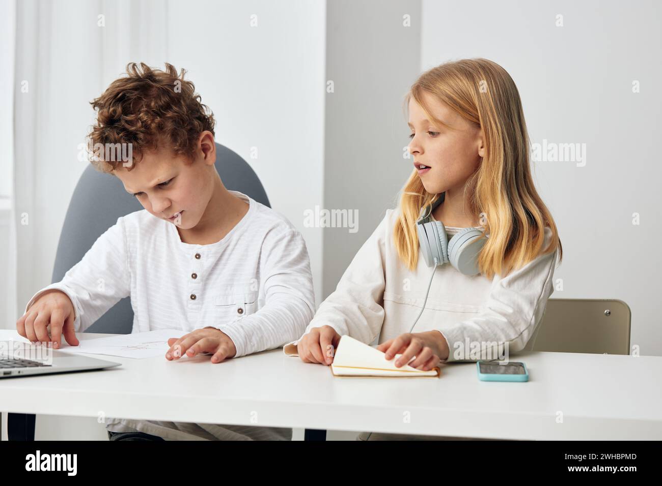 Happy Caucasian brother and sister studying together at home using ...