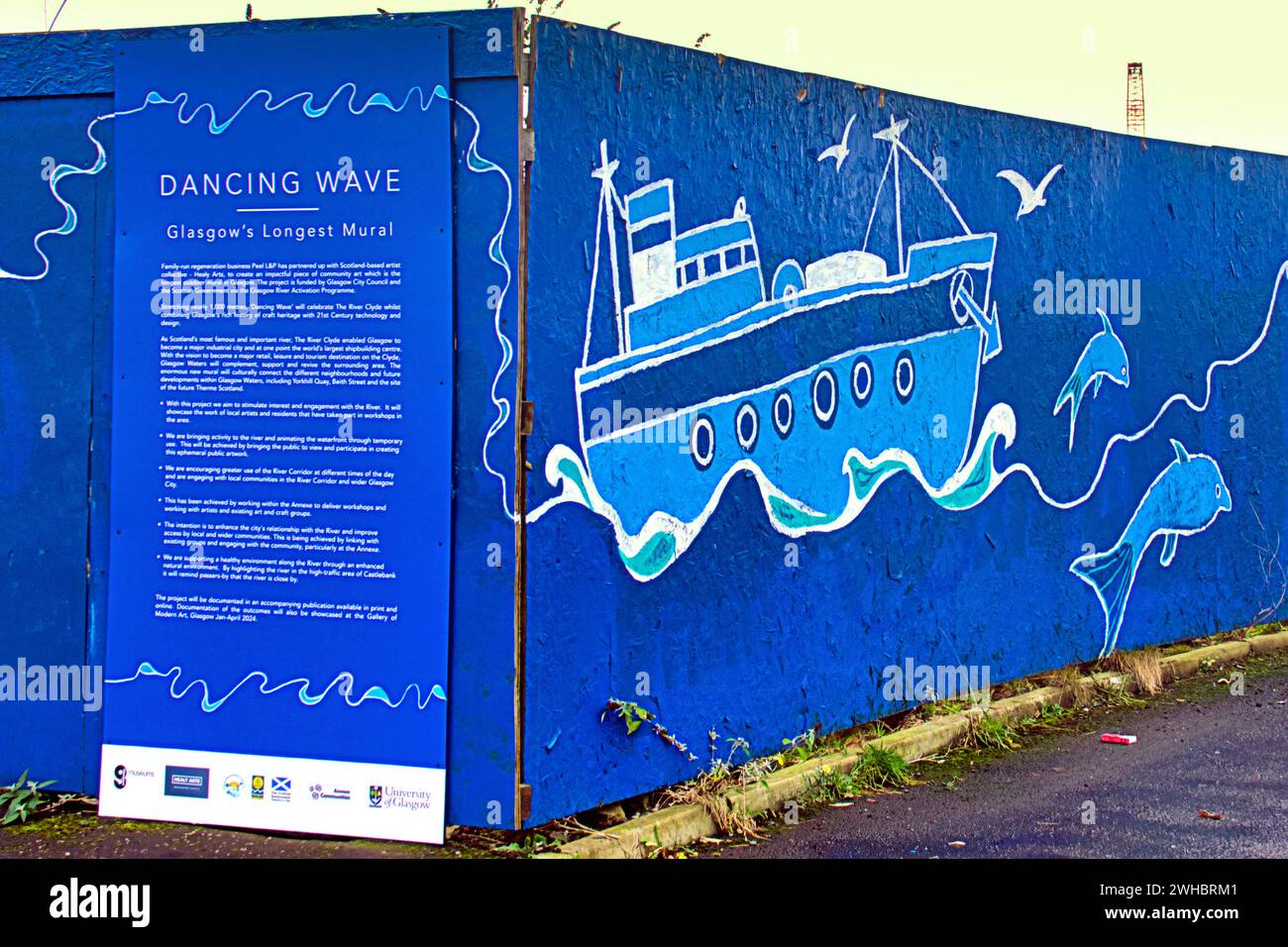 Glasgow, Scotland, UK. 9tht February, 2024.  Cloudy riverside and Dancing wave the longest mural in the city celebrates the heritage of the river clyde and runs along its bank illustrating its sites and history where the new bridge to govan is being built beside the museum and the clipper ship glenlee whilst the navy newest warship hms glasgow is being built on the other bank by bae systems. Credit Gerard Ferry/Alamy Live News Stock Photo