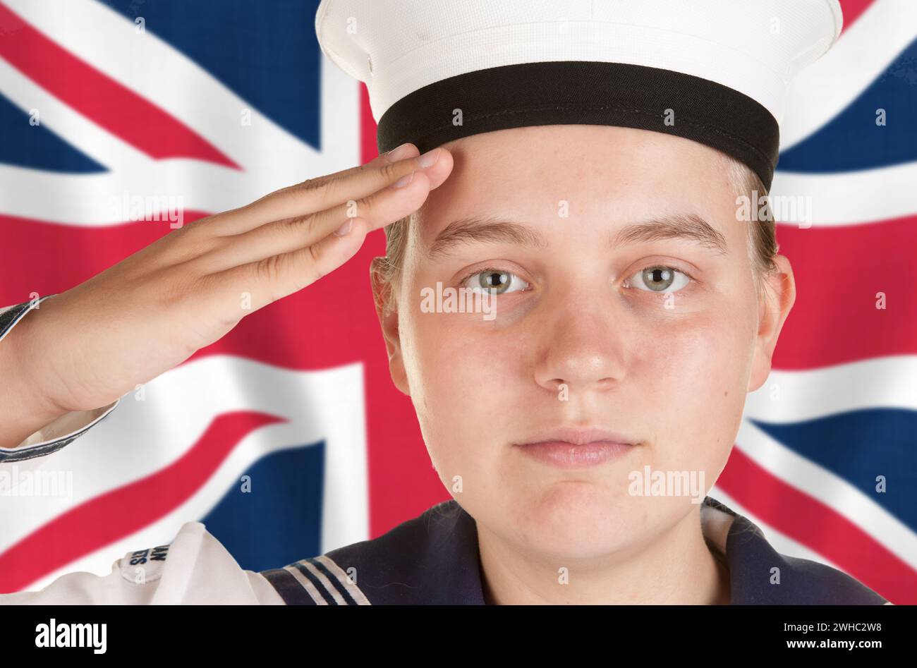 Young sailor saluting in front of union jack Stock Photo