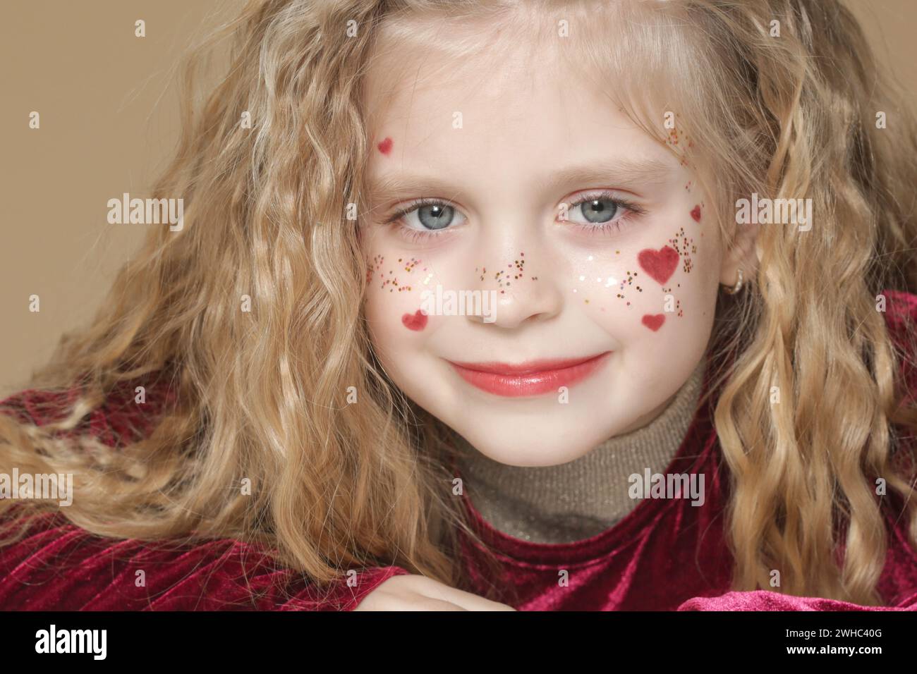 Portrait of cute little girl in red dress with long blonde hair and ...