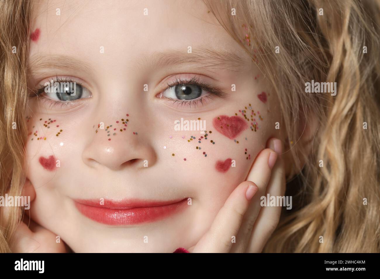Portrait of cute little girl in red dress with long blonde hair and ...