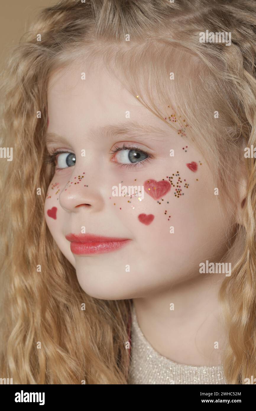 Portrait of cute little girl in red dress with long blonde hair and ...