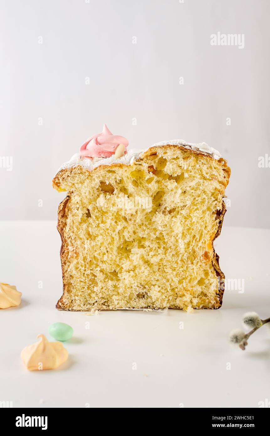 Place setting for Easter dinner on the white table with Easter cake with colorful topping, Decorative chocolate eggs sweets, willow and holiday decora Stock Photo