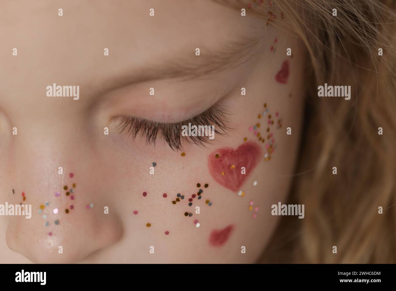 Close up of girl's closed eye with long lashes and glitters around Stock Photo