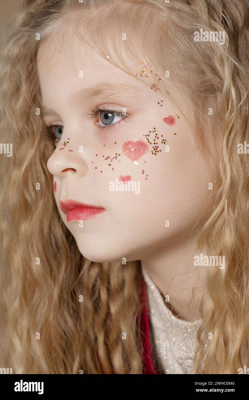 Portrait of cute little girl in red dress with long blonde hair and ...