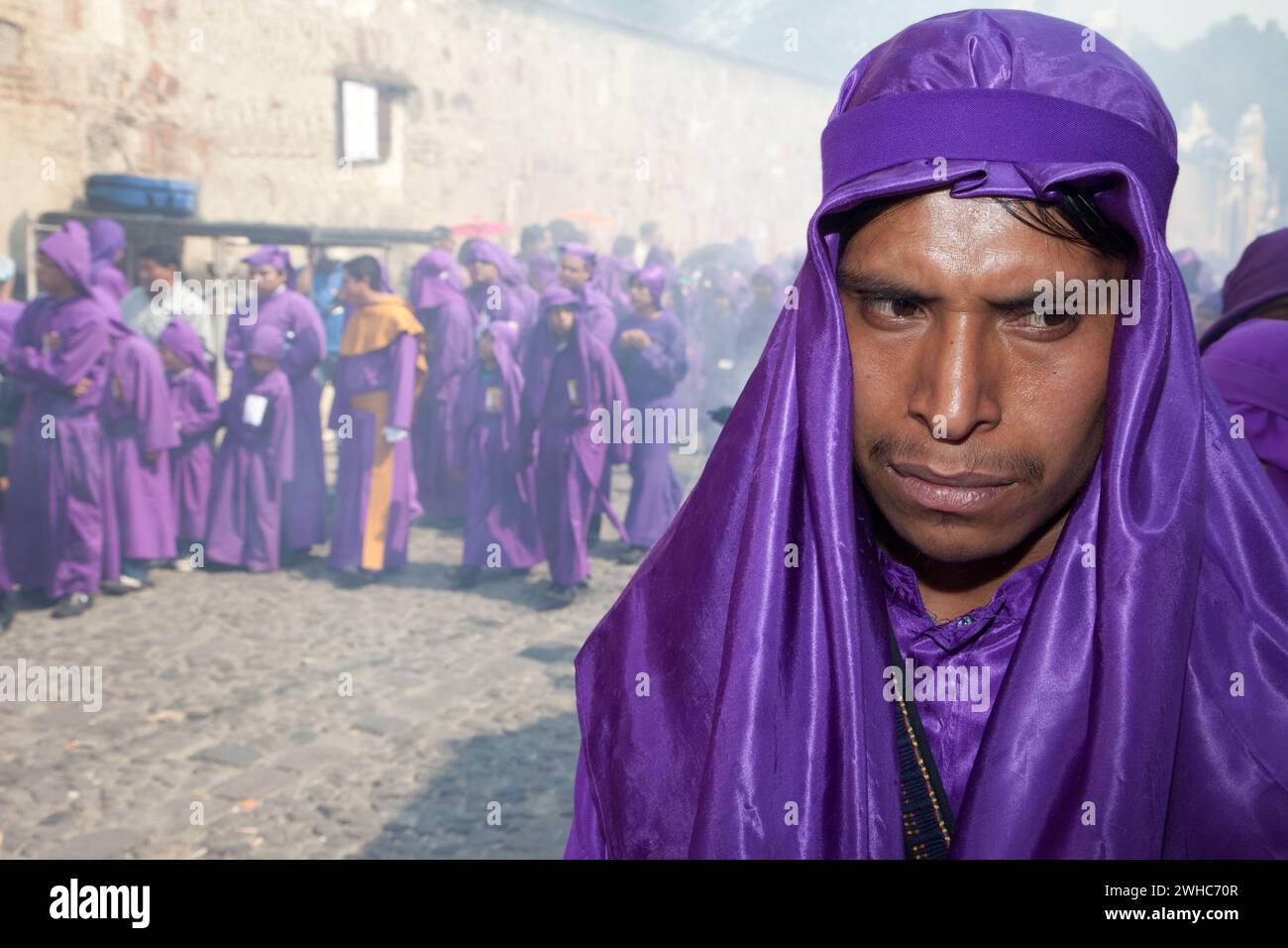 Antigua, Guatemala.   A Cucurucho Accompanying a Religious Procession during Holy Week, La Semana Santa.  Clouds of Incense in Background. Stock Photo