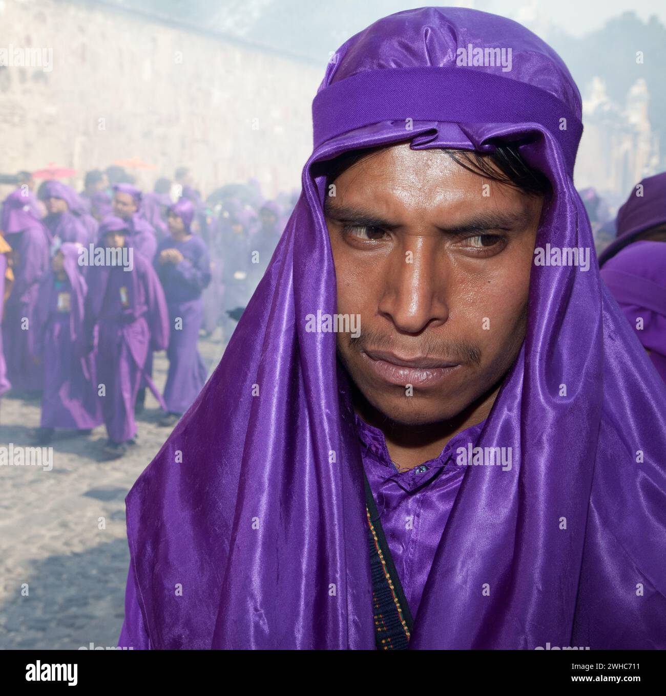Antigua, Guatemala.   A Cucurucho Accompanying a Religious Procession during Holy Week, La Semana Santa.  Clouds of Incense in Background. Stock Photo