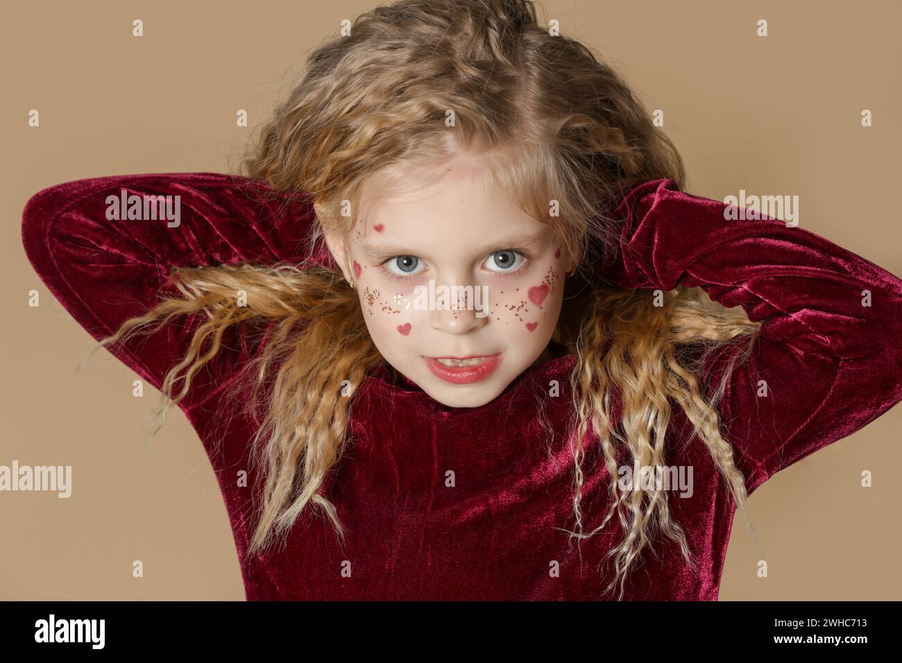 Portrait of cute little girl in red dress with long blonde hair and ...