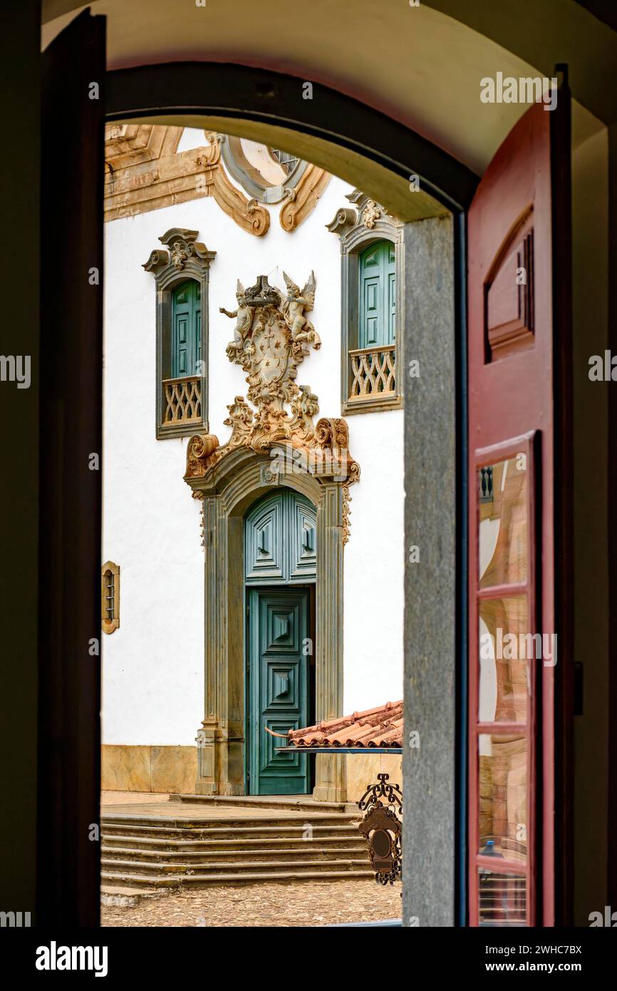 Baroque church front seen through the window of an old colonial-style house in the city of Mariana in Minas Gerais Stock Photo