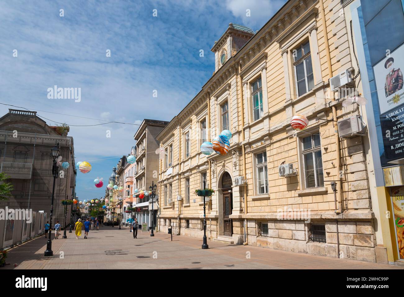 A lively city street with historic architecture and balloon decorations on a sunny day, pedestrian zone Alexandrovska, Russe, Ruse, Pyce, Bulgaria Stock Photo