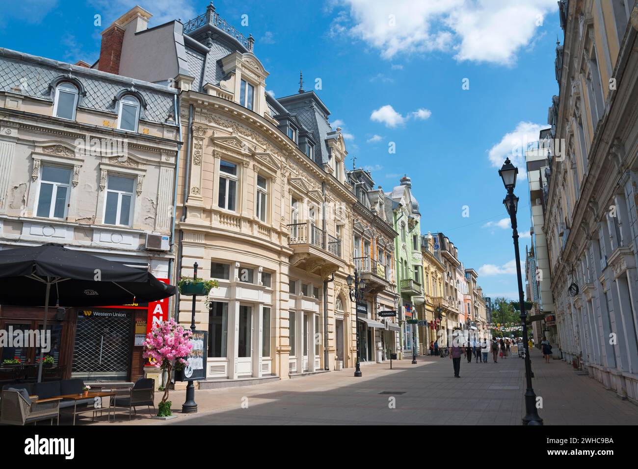 A lively city street with historic buildings under a blue sky on a ...