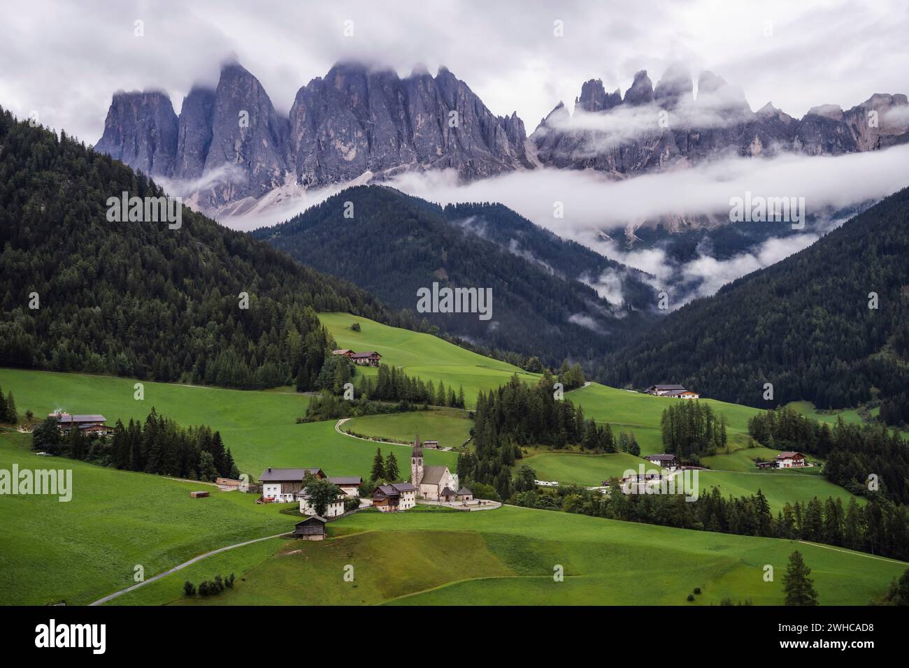 St Magdalena church in Val di Funes valley, Dolomites, Italy. Furchetta and Sass Rigais mountain peaks in background. Stock Photo