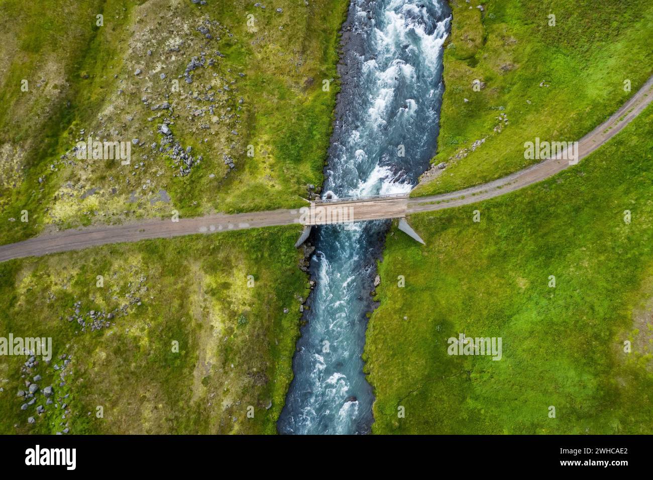 Iceland. Aerial view of road and small bridge over blue mountain river. Aerial scenic view of Iceland landscape. Travel vacation concept. Stock Photo