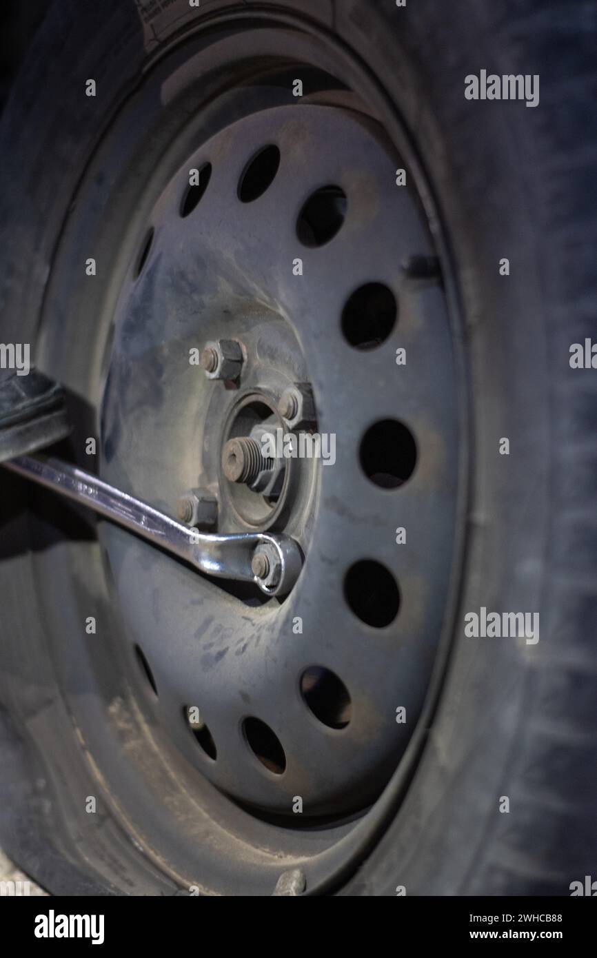 Vertical detail of an unrecognizable mechanic loosening lug nuts to