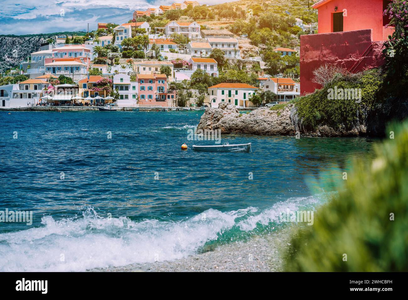 Summer vacations scenery. Mediterranean town Assos on Kefalonia in Greece. View of beautiful beach and colored houses. Stock Photo