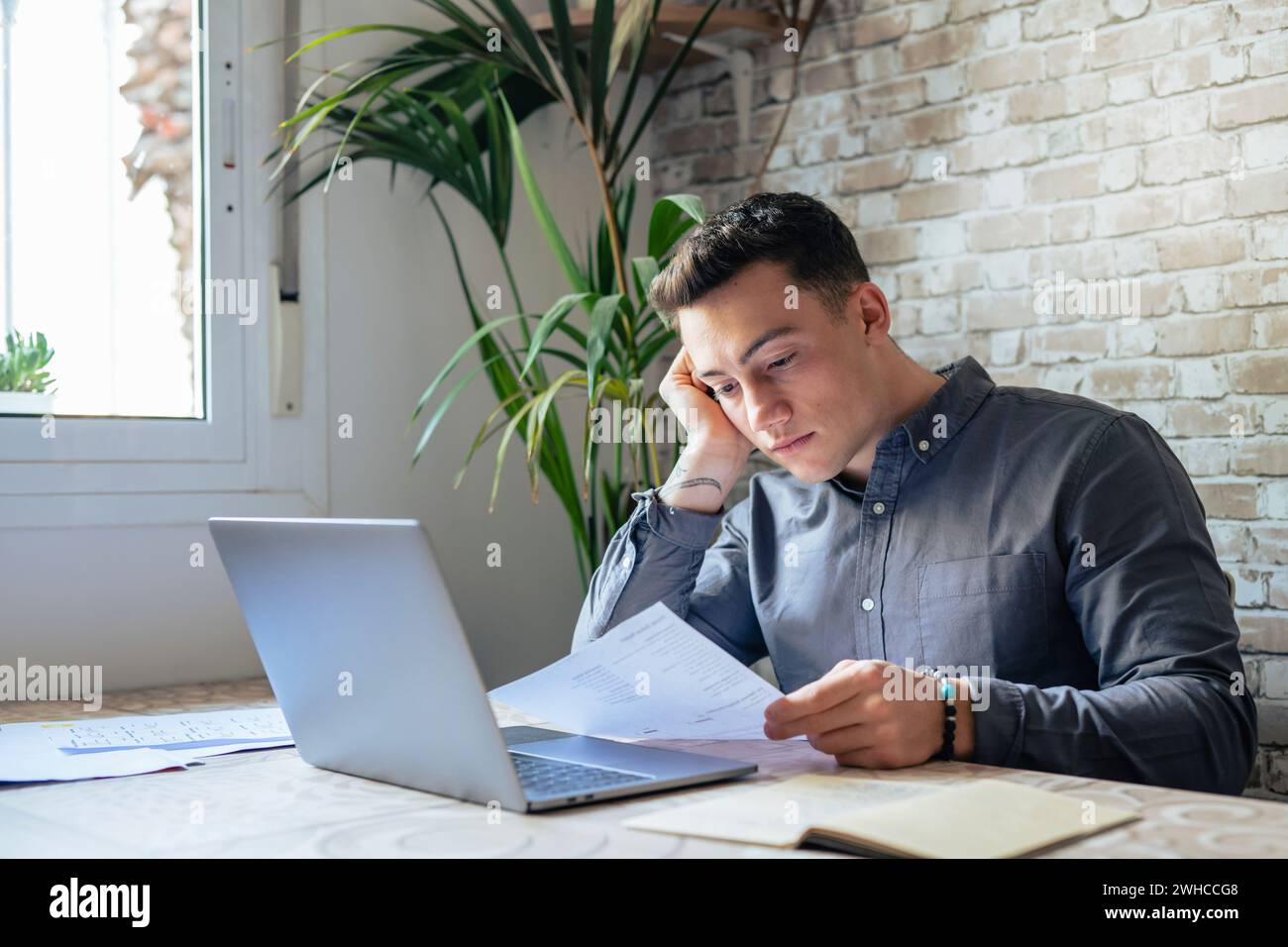 Confused frustrated young man reading letter, debt notification, bad financial report, money problem, money problem, upset student receiving bad news, unsuccessful exam or test results Stock Photo