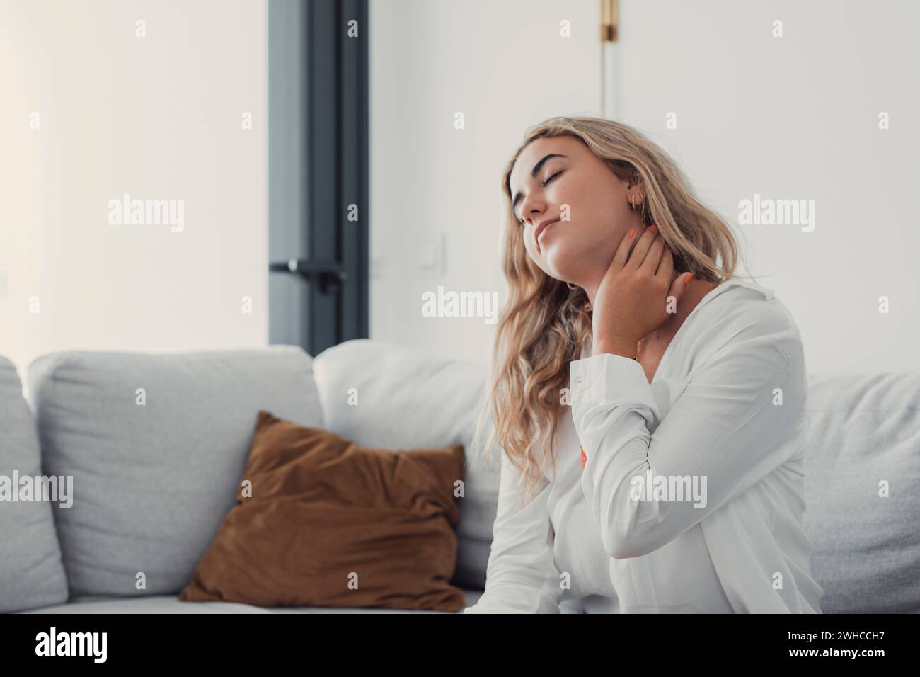 Close up tired woman massaging neck muscles after long sedentary work, exhausted girl feeling discomfort, unwell and unhealthy, suffering from strain or spasm, health problem concept Stock Photo