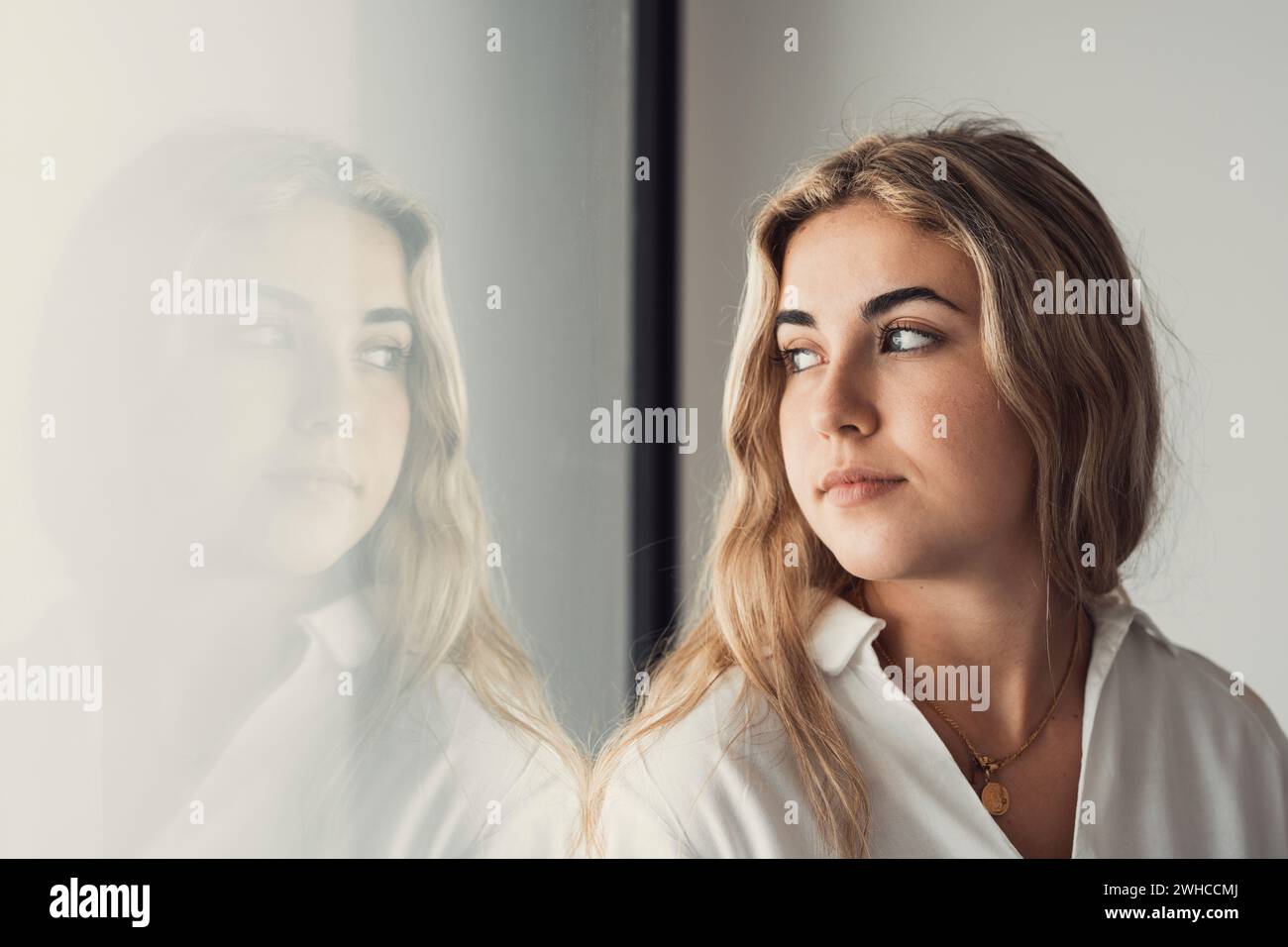 Unhappy thoughts. Worried young caucasian woman look at window feel lonely sad wait for boyfriend coming back after quarrel. Pessimistic millennial lady hide from life problems at home. Copy space Stock Photo