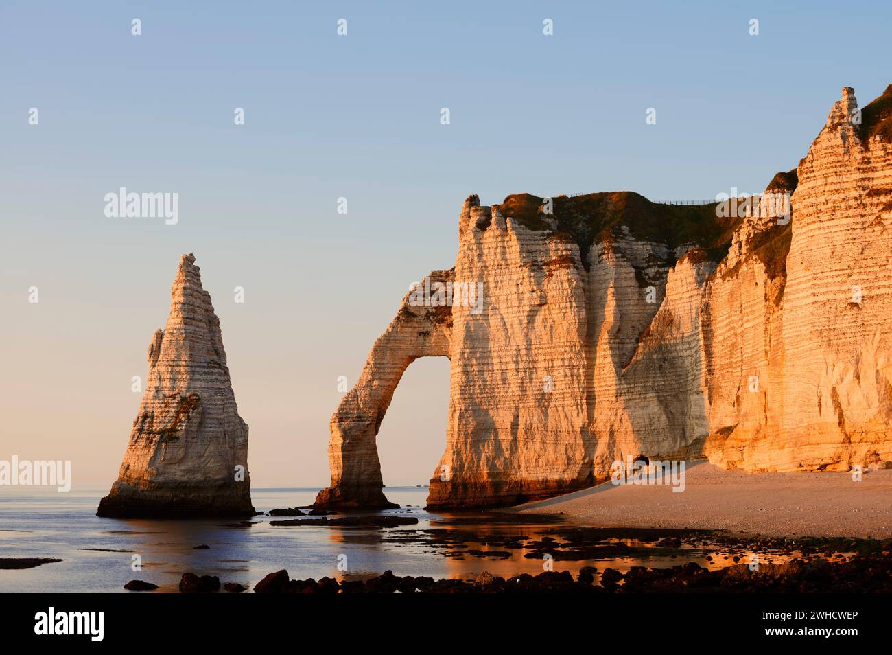 Steep cliffs with the Falaise d'Aval rock gate and the Aiguille díEtretat rock needle in the evening light, Etretat, Alabaster Coast, Seine-Maritime, Normandy, France Stock Photo