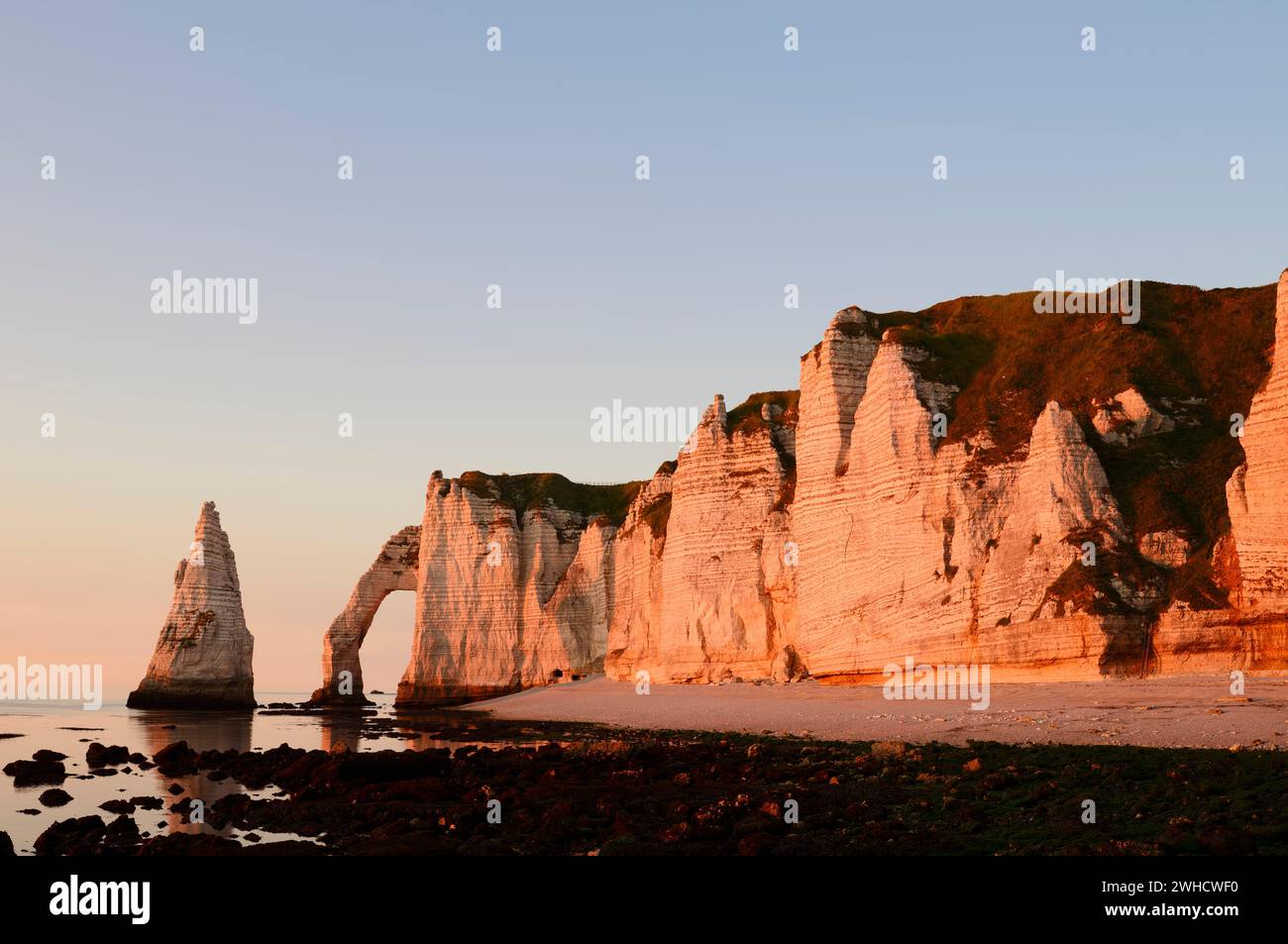 Steep cliffs with the Falaise d'Aval rock gate and the Aiguille díEtretat rock needle in the evening light, Etretat, Alabaster Coast, Seine-Maritime, Normandy, France Stock Photo